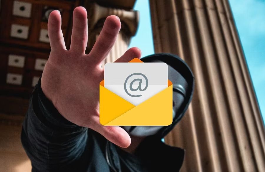 Personas con el rostro tapado con una careta y sujetando un logo de correo electrónic