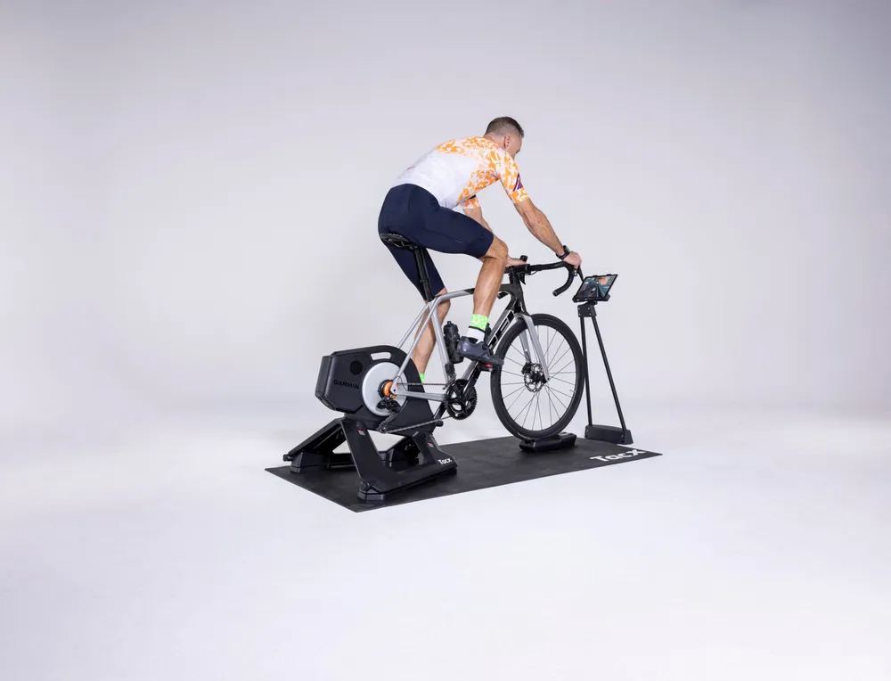 Imagen promocional de Zwift mostrando hardware y software para hacer ciclismo indoor